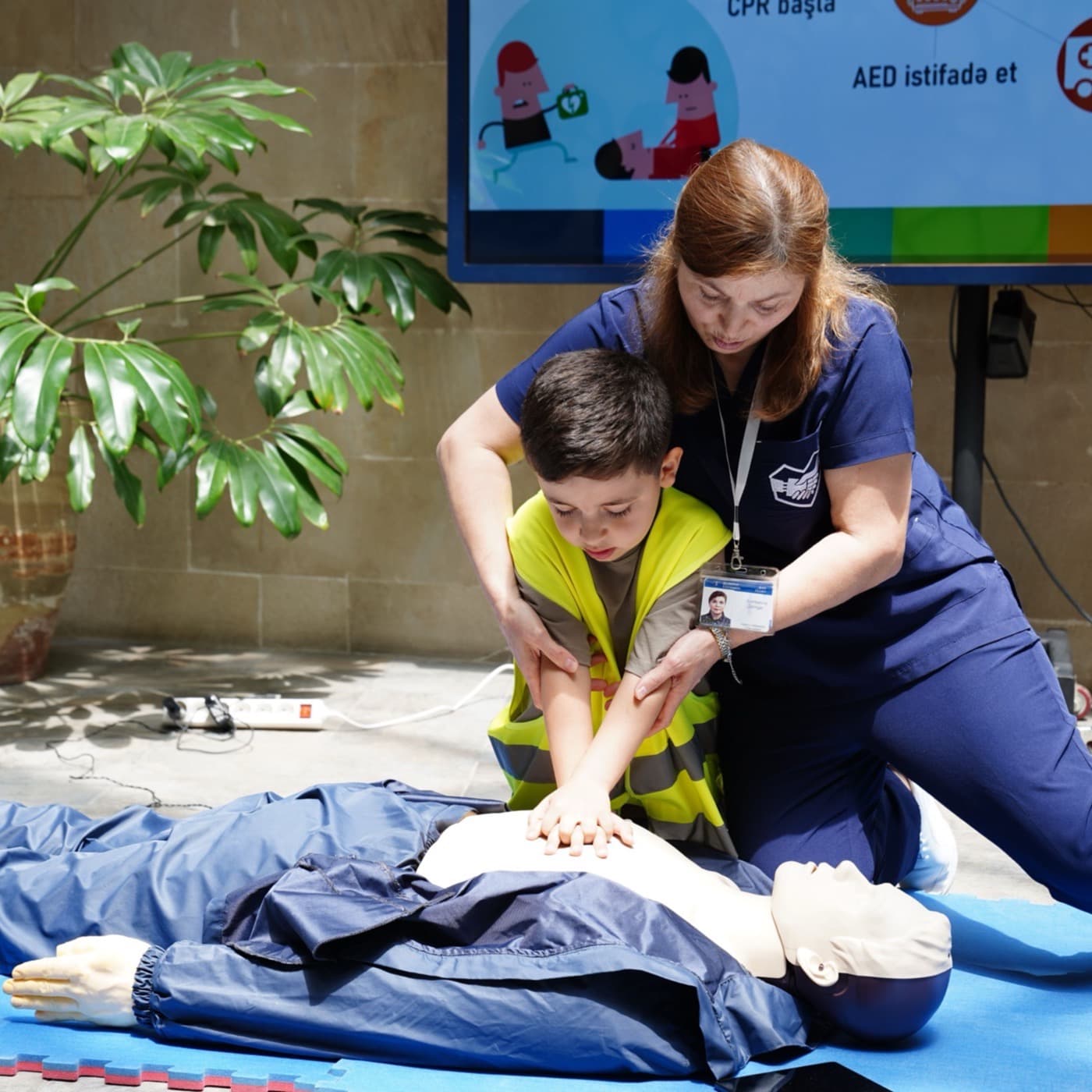 CPR instructor guiding a student through chest compressions